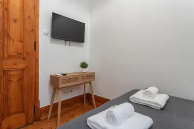 a bedroom with two beds and a tv on a wall at Privilege Apartment Aliança da Silva in the heart of Faro in Faro