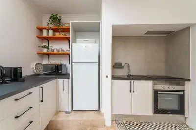 a kitchen with white cabinets and a refrigerator at Privilege Apartment Aliança da Silva in the heart of Faro in Faro