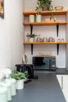 a kitchen with a microwave on a counter with plants at Privilege Apartment Aliança da Silva in the heart of Faro in Faro