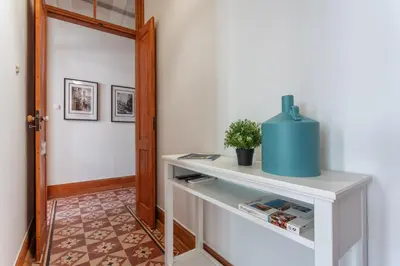 a hallway with a white table with a plant on it at Privilege Apartment Aliança da Silva in the heart of Faro in Faro