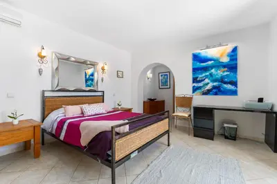 a bedroom with a bed and a desk at The Quinta - 3 Bedroom ensuite Villa, Swimming Pool, Beautiful Gardens, water features and lake in Almancil