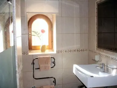 a bathroom with a sink and a window at The Quinta - 3 Bedroom ensuite Villa, Swimming Pool, Beautiful Gardens, water features and lake in Almancil