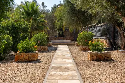 a walkway in a garden with plants and trees at The Quinta - 3 Bedroom ensuite Villa, Swimming Pool, Beautiful Gardens, water features and lake in Almancil