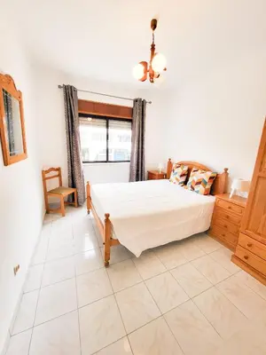 a bedroom with a large bed and a window at T1 Largo Frente - Familiar in Quarteira