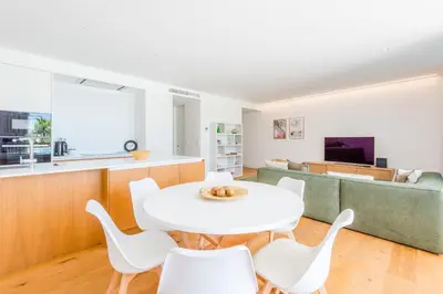a kitchen and living room with a white table and chairs at Lakes 24 at Praia da Falesia Vilamoura in Vilamoura
