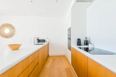 a kitchen with white counters and wooden cabinets at Lakes 24 at Praia da Falesia Vilamoura in Vilamoura