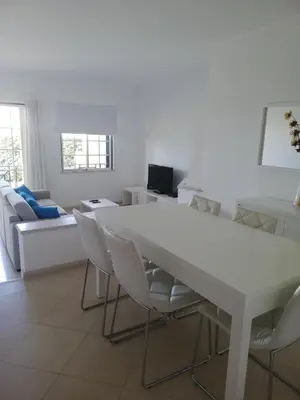 a white dining room with a white table and chairs at Villa V2 V in Olhos de Água