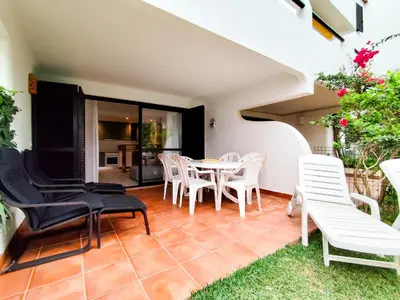 a patio with white chairs and a table at Solar dos Pinheiros in Vilamoura