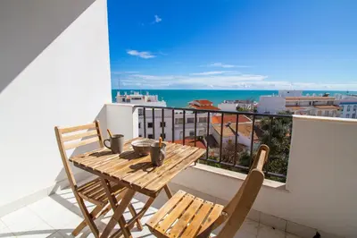 a table and chairs on a balcony with a view of the ocean at Old Town Apartment Panoramic NearThe Beach in Albufeira