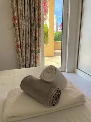 a roll of towels sitting on top of a bed at A Villa in Quarteira