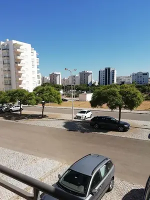 a car parked on the side of a street with buildings at Apartamento laranja in Quarteira