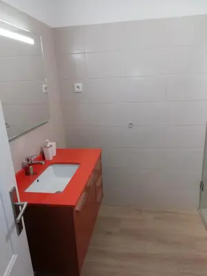 a bathroom with a red sink and a mirror at Apartamento laranja in Quarteira