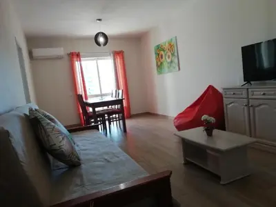 a living room with a couch and a table at Apartamento laranja in Quarteira