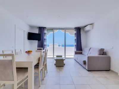 a living room with a table and a couch at AL - Atlântida Penthouse in Quarteira