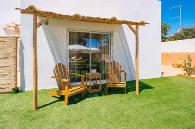 a gazebo with chairs and a table in a yard at Coral Boutique Suites in Albufeira