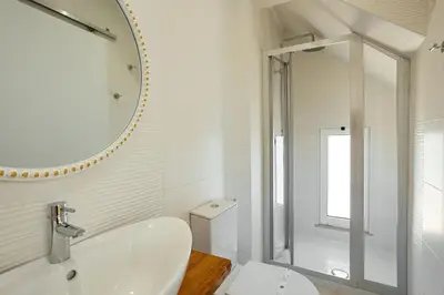 a white bathroom with a sink and a mirror at Coral Boutique Suites in Albufeira
