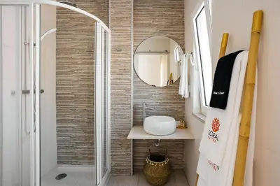 a bathroom with a sink and a mirror at Coral Boutique Suites in Albufeira