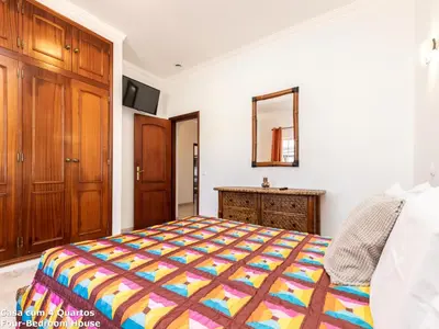 a bedroom with a bed and a dresser and a mirror at Akisol Albufeira Sun in Albufeira