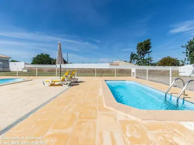 a swimming pool with a patio and an umbrella at Akisol Albufeira Sun in Albufeira