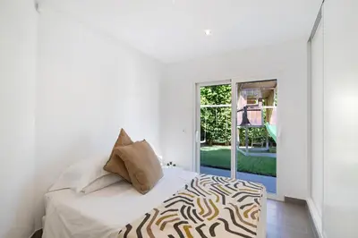 a white bedroom with a bed with a zebra print pillow at Pine Lodge in Vilamoura