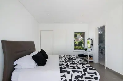 a white bedroom with a black and white bed at Pine Lodge in Vilamoura