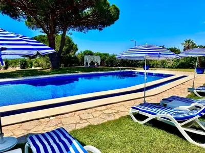 two chairs and umbrellas next to a swimming pool at SOLAR DO MONTE 1 in Albufeira