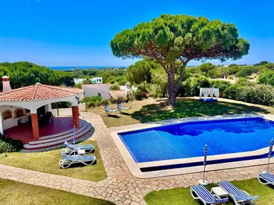 a swimming pool in a yard with chairs and a gazebo at SOLAR DO MONTE 4 in Albufeira
