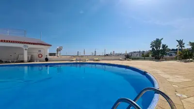 a large blue swimming pool next to a building at T3 Centro de Albufeira com piscina in Albufeira