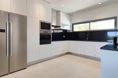 a kitchen with white cabinets and a stainless steel refrigerator at Vistas Mar Villas D by Stay ici Algarve Holiday Rental in Albufeira