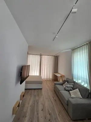 a living room with a couch and a tv at The Singular - Downtown Studio in Faro
