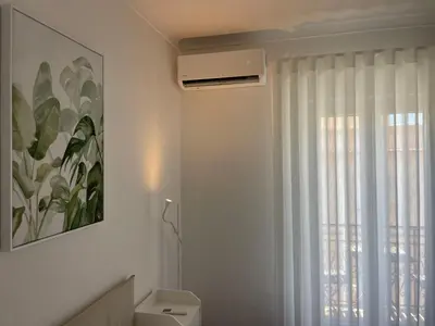 a bathroom with a window and a air conditioner at Porta 12 in Faro