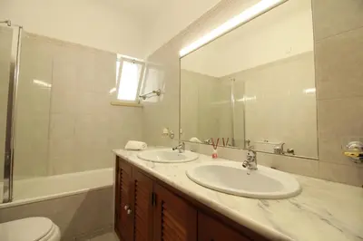 a bathroom with a sink and a toilet and a mirror at Porta 12 in Faro