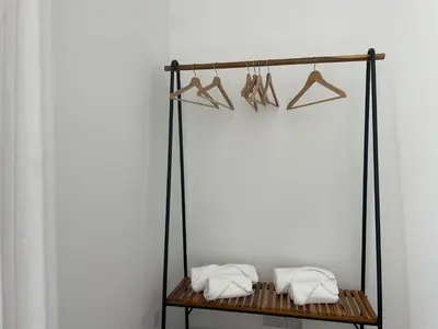 a shelf with towels and hangers on a wall at Porta 12 in Faro