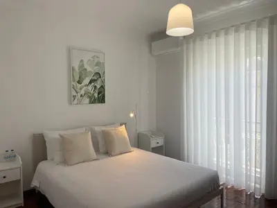 a bedroom with a white bed and a window at Porta 12 in Faro