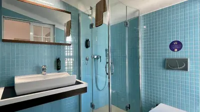 a bathroom with a sink and a shower with blue tiles at Poço by Check-in Portugal in Albufeira