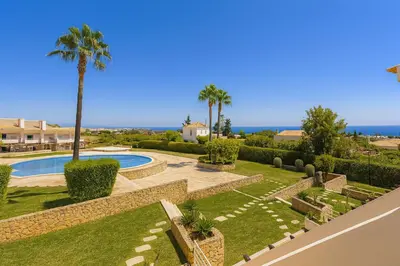 a garden with a swimming pool and palm trees at Votre refuge en bord de mer ! in Albufeira