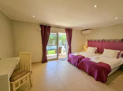 a bedroom with a large bed with a purple headboard at FLH Quinta das Salinas Triplex with Terrace & Pool in Vale do Lobo