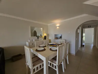 a dining room with a white table and chairs at FLH Quinta das Salinas Triplex with Terrace & Pool in Vale do Lobo