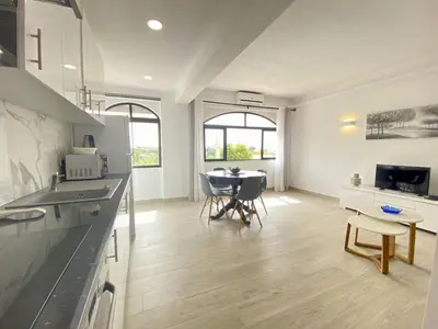 a kitchen and dining room with a table and chairs at Albufeira Central 6 by Homing in Albufeira