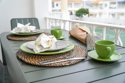 a table with plates and coffee cups on a balcony at Martina Apartment - SeaView in Albufeira