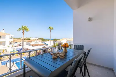 a blue table on a balcony with a view of a pool at Martina Apartment - SeaView in Albufeira