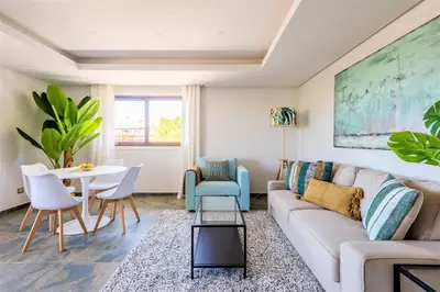 a living room with a couch and a table and chairs at Falesia Beach C in Albufeira