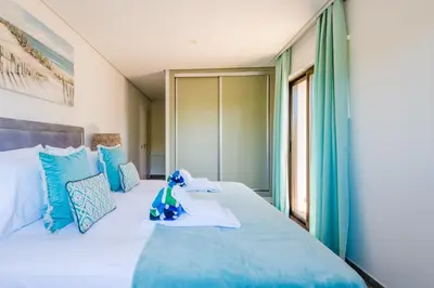 a bedroom with a large bed with blue pillows at Falesia Beach C in Albufeira
