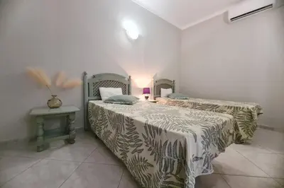a bedroom with two beds and a table with a lamp at Cosy & Airy @ Albufeira in Albufeira