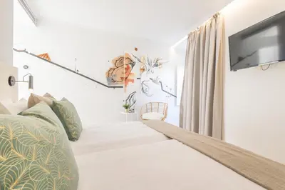a hotel room with a bed and a flat screen tv at LODO Suites Ria - Private Room by HD in Faro