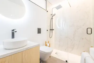 a bathroom with a shower and a toilet and a sink at LODO Suites Ria - Private Room by HD in Faro