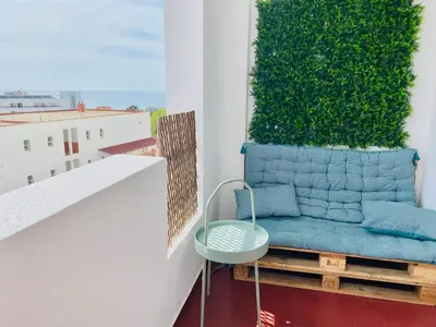 a blue chair on a balcony with a green wall at Renovated Oasis Ocean View 1BD Wi-Fi Beach 3 min in Albufeira