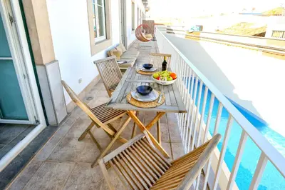 a table on a balcony with a bowl of fruit at Lovely Faro Apartment in Faro