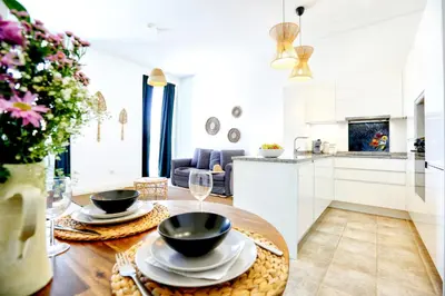 a kitchen and living room with a table with bowls at Lovely Faro Apartment in Faro