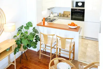a kitchen with a counter with chairs and a table at Ria Formosa Vista Duplex Charm in downtown Faro in Faro